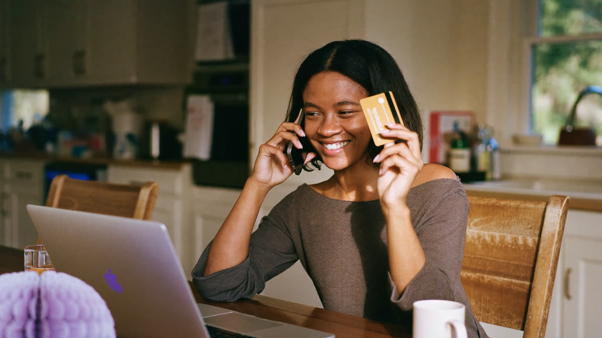 A customer pays by card during a phone call at her kitchen table
