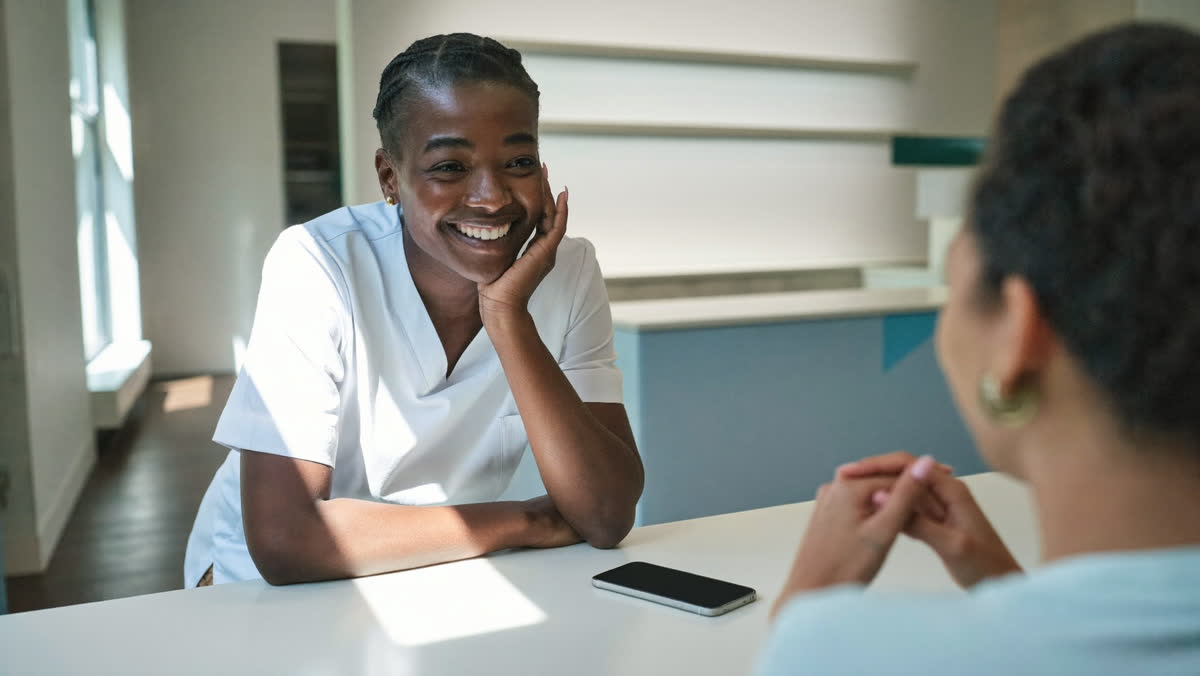 Dental receptionist smiling with a patient at the front desk