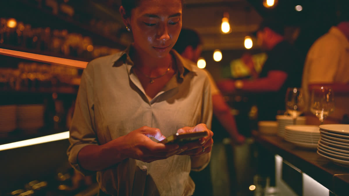 Restaurant owner checking messages during evening service