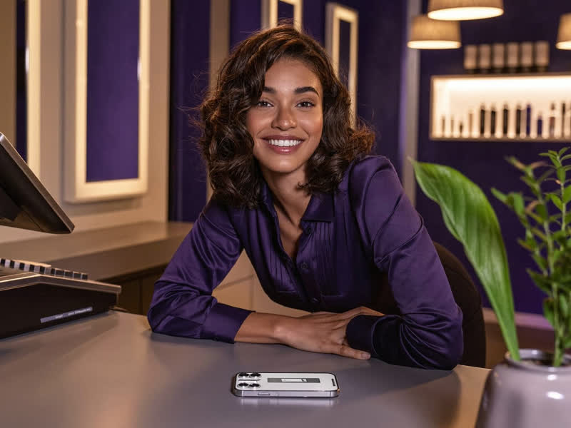 Salon owner at her counter while an AI agent handles customer messages